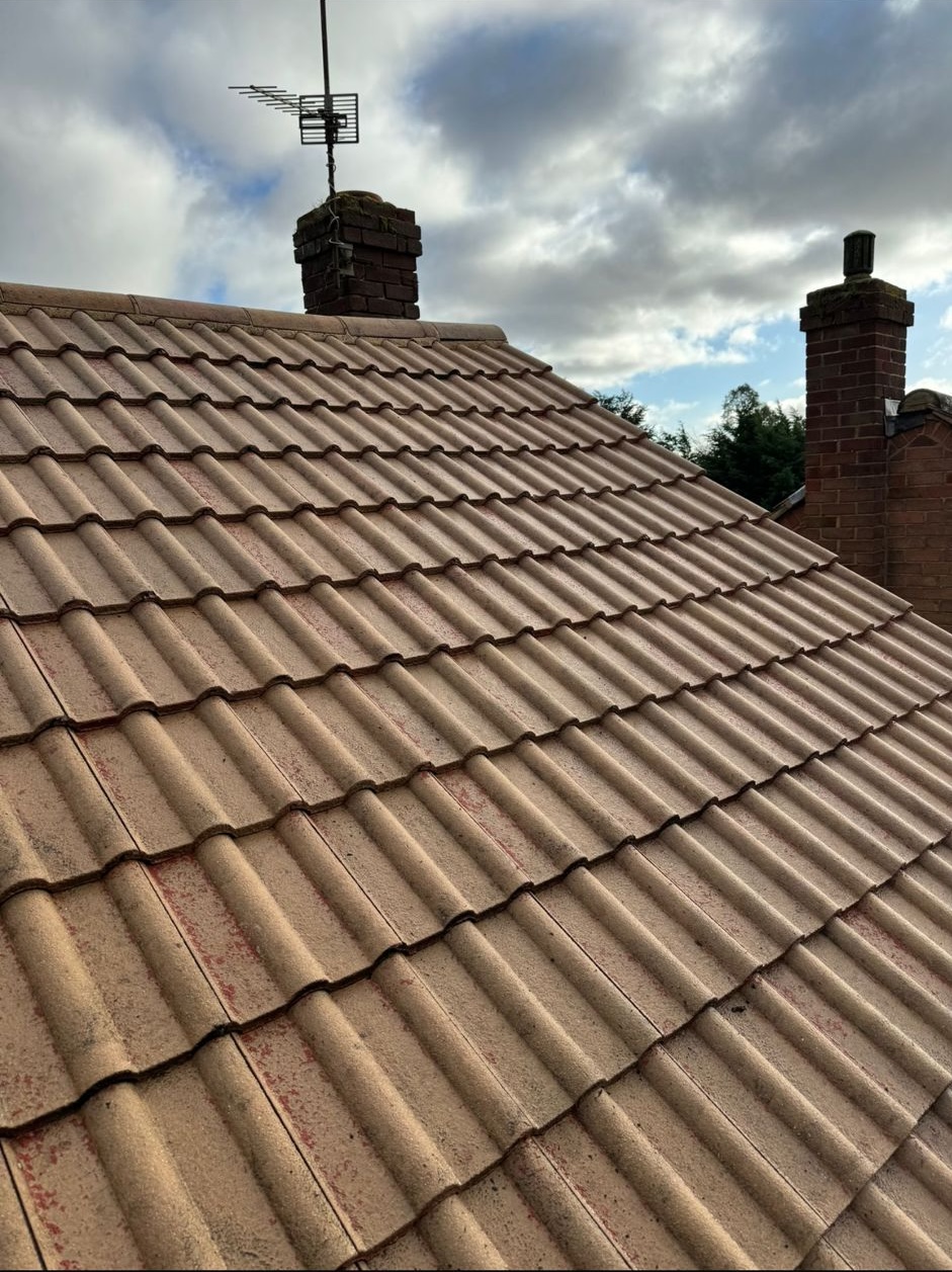 Concrete tiled roof with chimneys and moss traces — HomeShield roof cleaning in Dorset