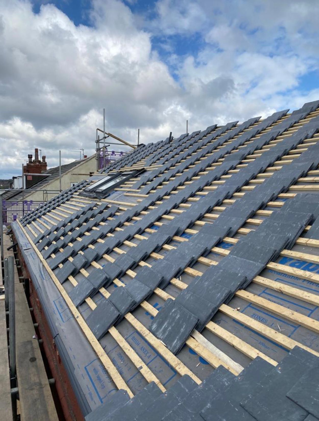 HomeShield roofers laying natural slate on a pitched roof in Dorset